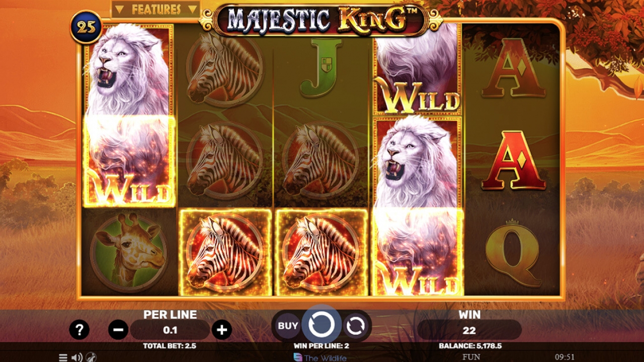 Jogo base do slot Majestic King, da Spinomenal, destacando o recurso de wilds empilhados em uma configuração de 5 rolos e 25 linhas de pagamento.