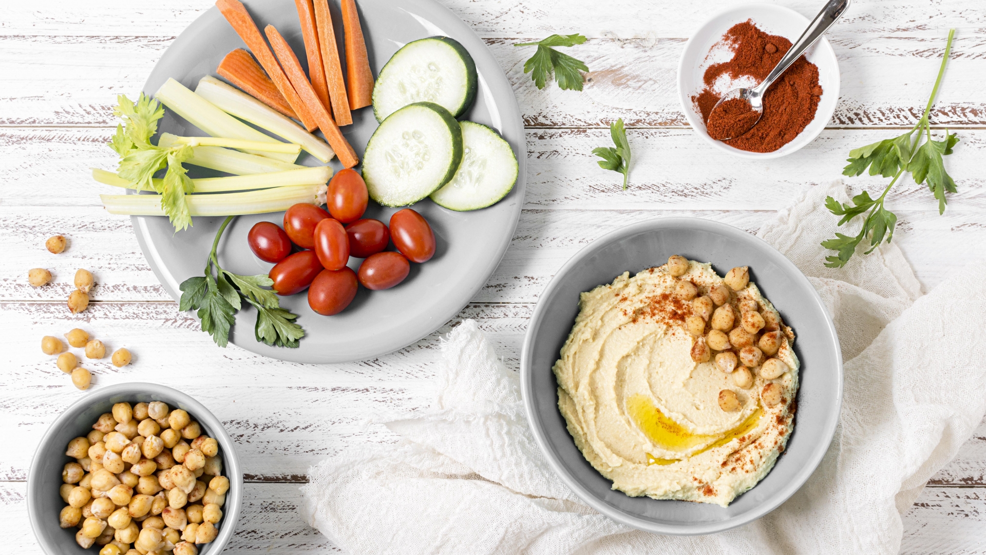 Verduras frescas con hummus Un plato con verduras en rodajas como zanahorias y pepinos, servidos con un tazón de hummus.