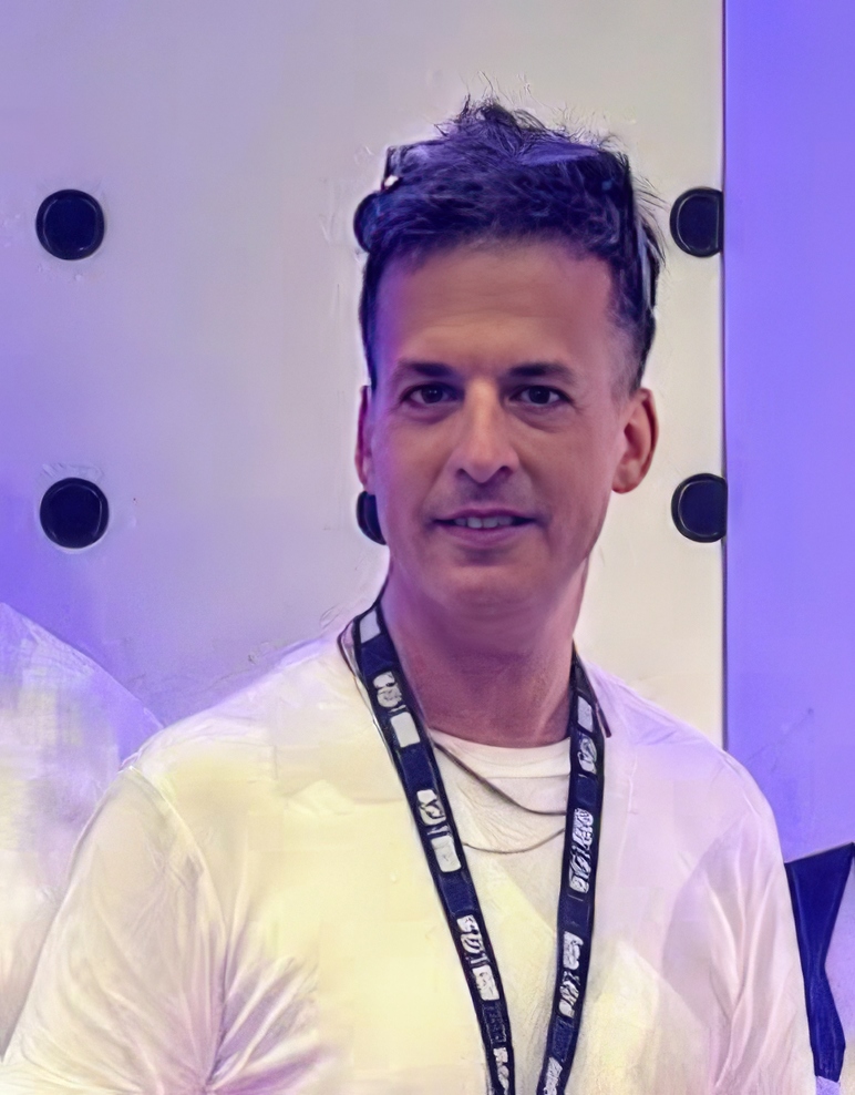 Shay Peretz, Chief Operating Officer of Skywind Group, smiling at a corporate event.