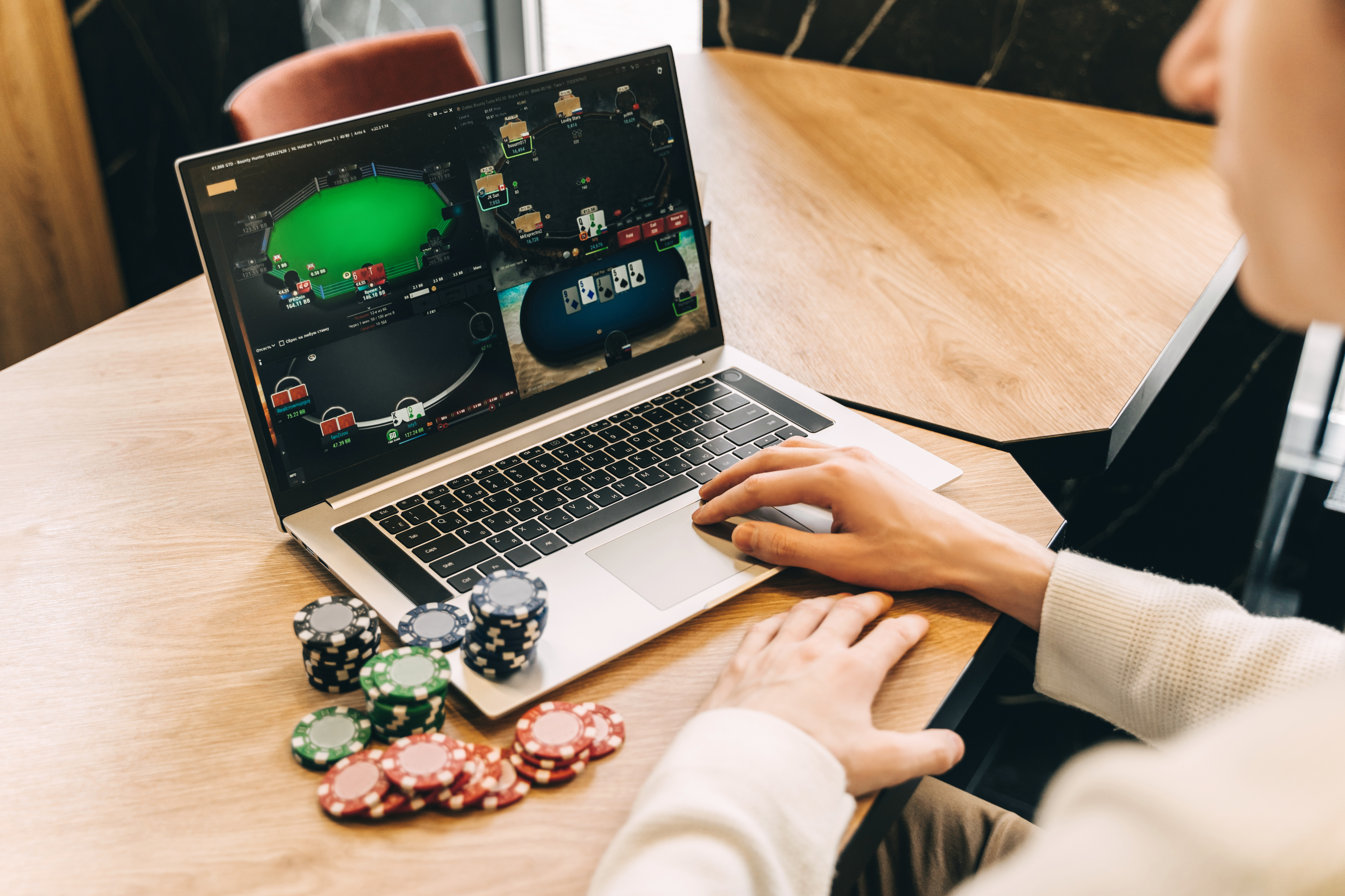 Hombre inmerso en un juego de cartas en línea dentro de un casino virtual.