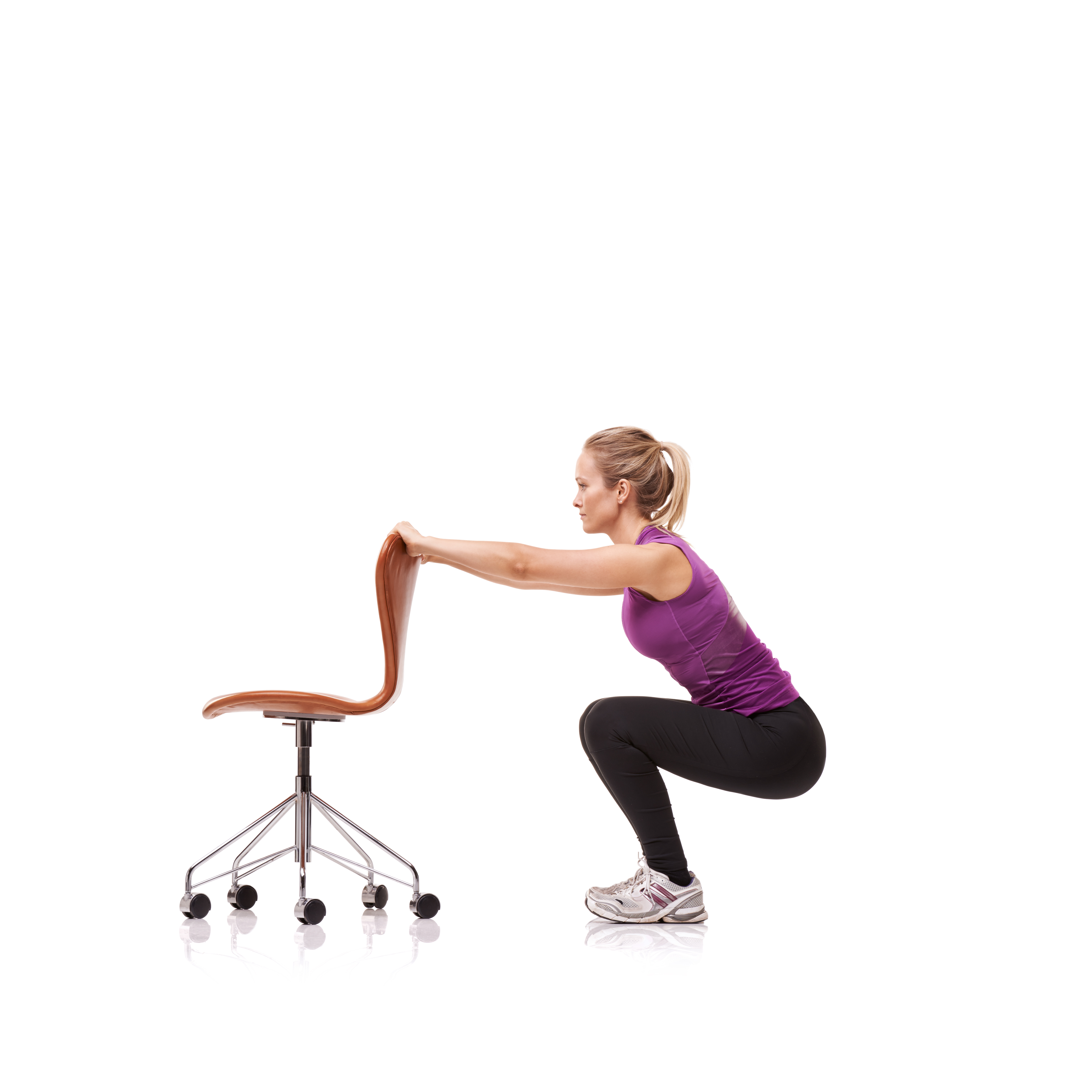 A woman performing chair squats in a modern office, demonstrating an easy way to stay active during the workday.